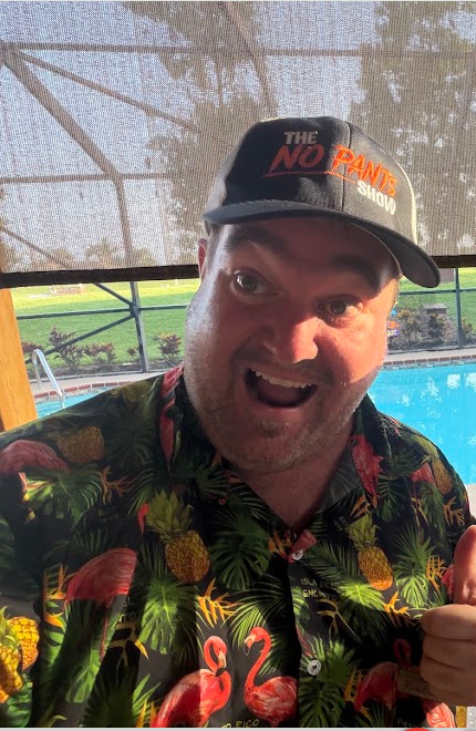 Richard poolside in flamingo Hawaiian shirt giving thumbs up